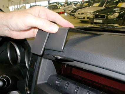 Ett bilinstrument med en hand som håller i en del av interiören.