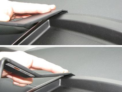 En hand visar hur man använder ett verktyg på en bils interiör.