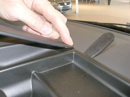 En hand justerar en panel på dashboarden i en Volkswagen Caravelle.