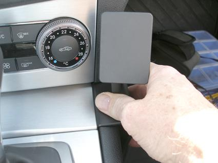 Hand som justerar en vinklad kontrollpanel i en Mercedes Benz C-Klass 07-10.