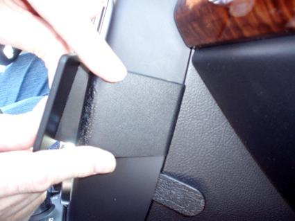 En person installerar en panel i en bilinteriör.