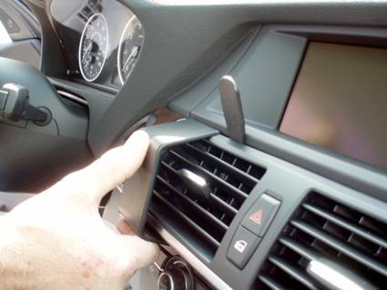 En hand pekar på en luftventil i interiören av en BMW.