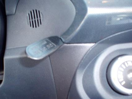 En del av instrumentbrädan med en spak och en knapp.