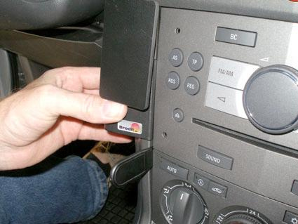 En hand sätter in en USB-enhet i en bilstereo.