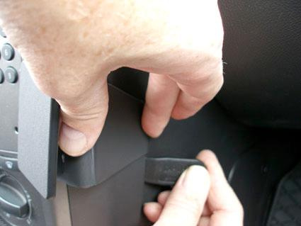 Hand som justerar eller tar bort en del av instrumentpanelen i en Opel Antara.