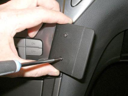 Hand som håller en skruvmejsel mot en panel i en Ford Mondeo.