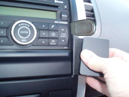 En hand som håller i en vinklad bilmontering på en dashboard.