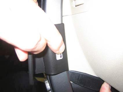 Hand som håller i en liten panel nära ratten i en Nissan X-Trail 08-13.