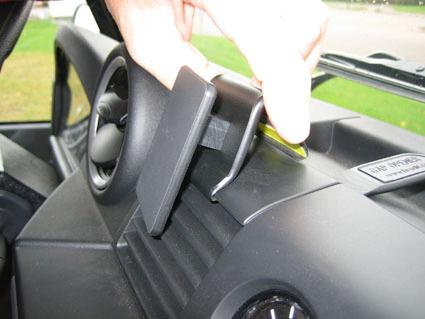 En hand justerar en del av bilens instrumentbräda.