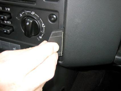 En hand som placerar en del på instrumentbrädan i en Landrover Defender.