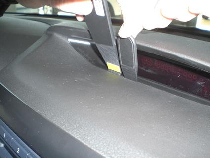 En hand justerar eller installerar något på instrumentpanelen i en Subaru Forester/Impreza.