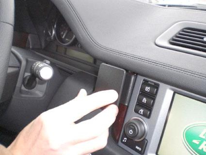 En hand justerar ett kontrollerande inslag i en bils dashboard.