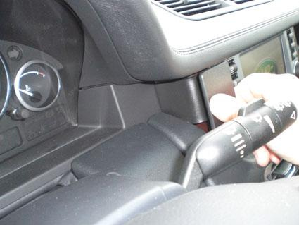 En bild som visar en hand som justerar kontroller i en bilinteriör.