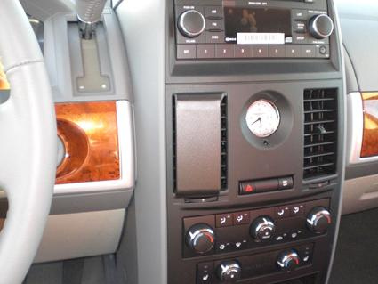 Instrumentpanel med kontroller, klocka och trädetaljer.