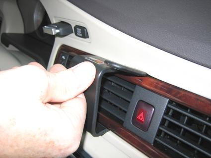 Hand som justerar en del av träpanelen i en Volvo S80/V70/CX70.