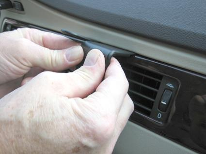 En person installerar en träpanel i en bilventil.