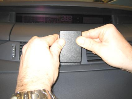 En person fäster en svart del på instrumentpanelen i en Renault Espace.