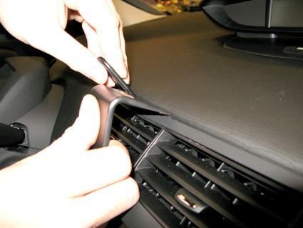 En person tar bort en del av instrumentpanelen i en Citroen C4.