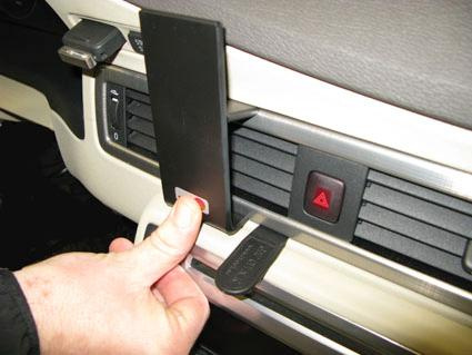 Hand som trycker på en knapp på en bils ventilationspanel.