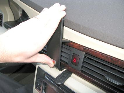 En hand som justerar en panel på instrumentbrädan i en Volvo S80/V70/CX70.