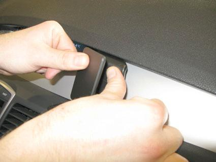 En person installerar en del på instrumentpanelen i en Renault Laguna.