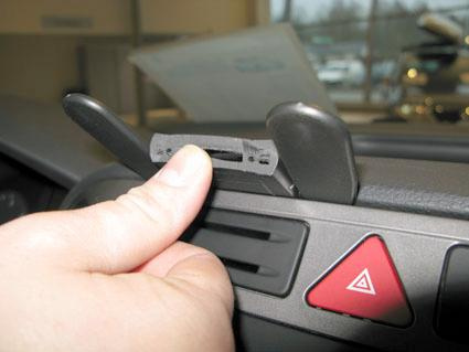 En hand trycker på en del av bilens instrumentpanel.