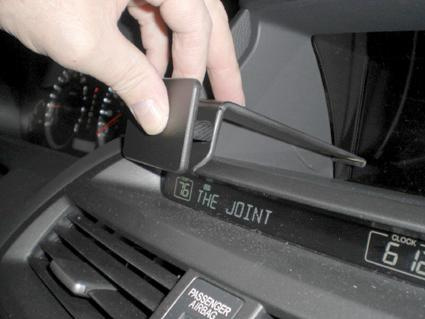 En hand som justerar en hållare på instrumentpanelen i en Honda Accord.