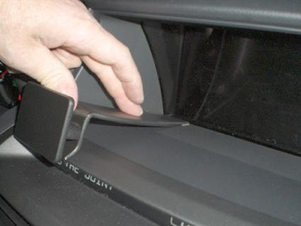 En hand trycker på en centrerad del i en bilinteriör.