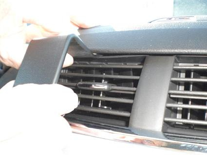 En hand justerar en del av luftventilen i en Chevrolet Malibu 08-12.