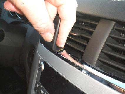 En hand justerar en ventilationsöppning i en Chevrolet Malibu 08-12.