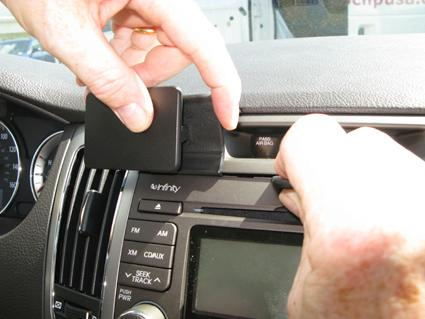 En person installerar en enhet i bilens instrumentpanel.