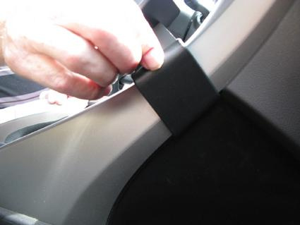 En hand justerar ett litet komponent på interiören av en Honda Accord 09-12.