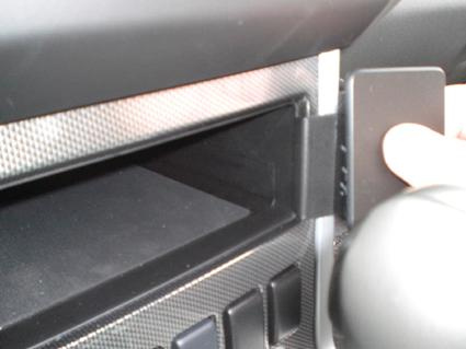 En hand som öppnar ett fack i en bilinteriör.