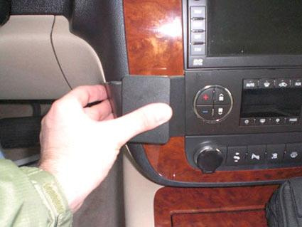 En person trycker på en komponent i bilen, troligen en kontroller.