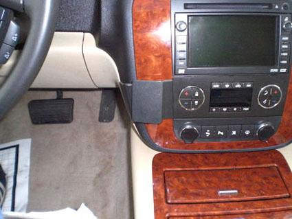 Instrumentpanel med infotainmentsystem, trädetaljer och fotpedal.