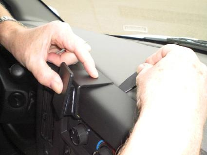 En person installerar en del på instrumentbrädan av en Chevrolet Express.