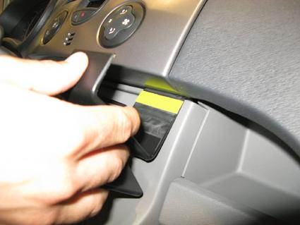 En hand justerar en del i instrumentpanelen på en Renault Kangoo.