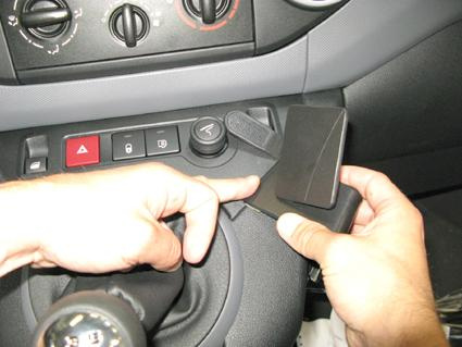 En hand justerar en del i bilens instrumentbräda.