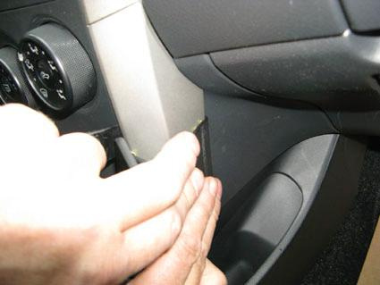 En hand justerar en del vid instrumentbrädan i en Toyota Corolla 08-11.