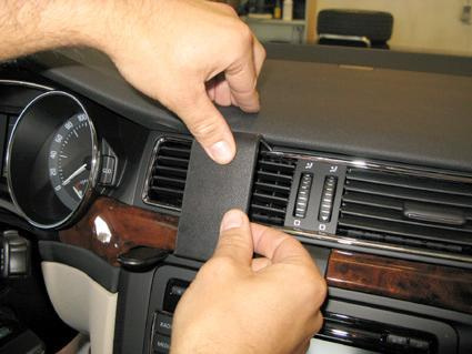 En person justerar eller installerar en del på Skoda Superb:s instrumentpanel.