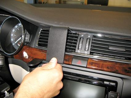 En hand justerar en panel ovanför bilens luftventiler.