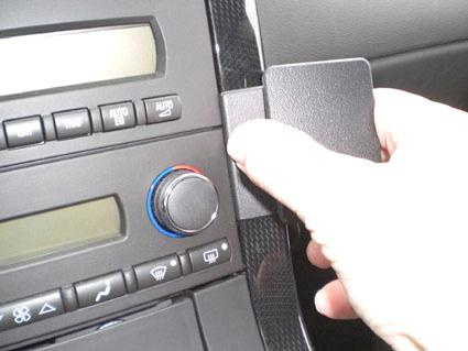 En hand som installerar en monteringsbygel i en Chevrolet Corvette.