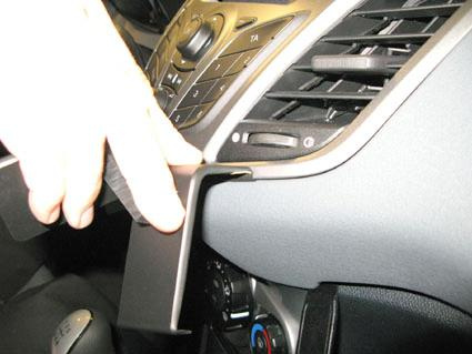 En hand justerar en del av instrumentpanelen i en Ford Fiesta.