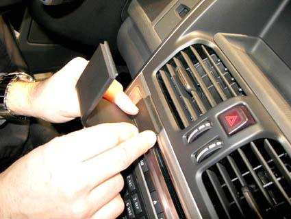 En hand installerar en del i Volvo XC60:s instrumentpanel.