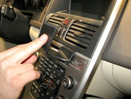 En hand pekar på en del av instrumentpanelen i en Volvo XC60.