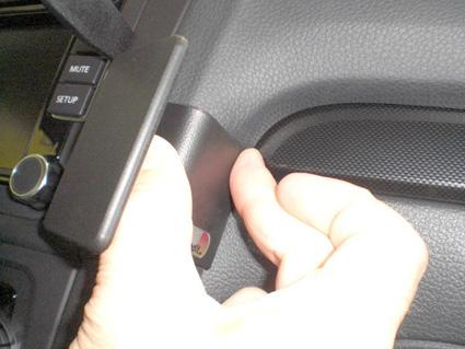 En hand justerar en del av bilens inredning.