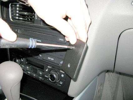 En hand skruvar på en panel i en Audi Q5-inredning.