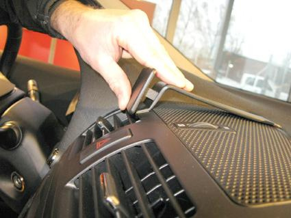 En hand justerar en del av bilens inredning.