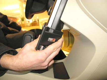 Hand som justerar en del av bilens interiör, troligtvis sitsens låsmekanism.