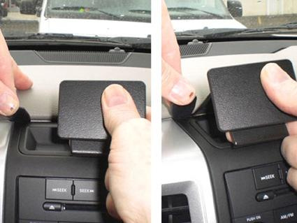 Visar en hand som avlägsnar ett lock från instrumentbrädan i en Dodge Ram.